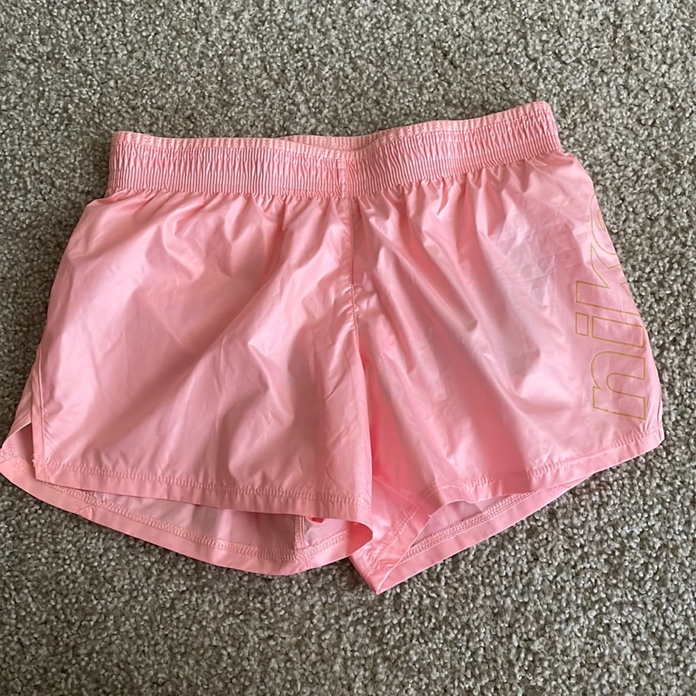 Standard fit pink Nike running shorts with gold detail. NWT